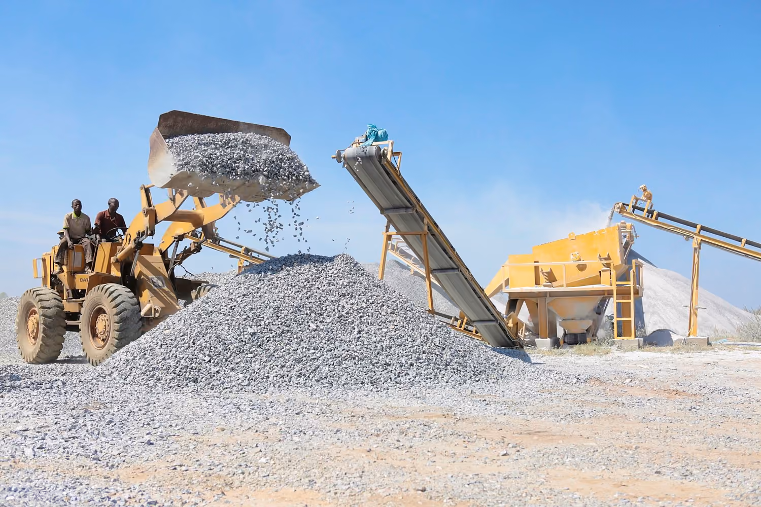 Wheel loader feeding a mobile crushing and screening plant at a quarry